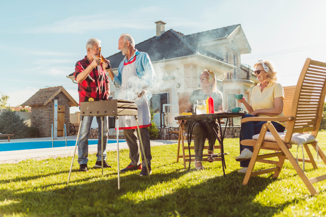 Elderly neighbors having backyard barbecue party