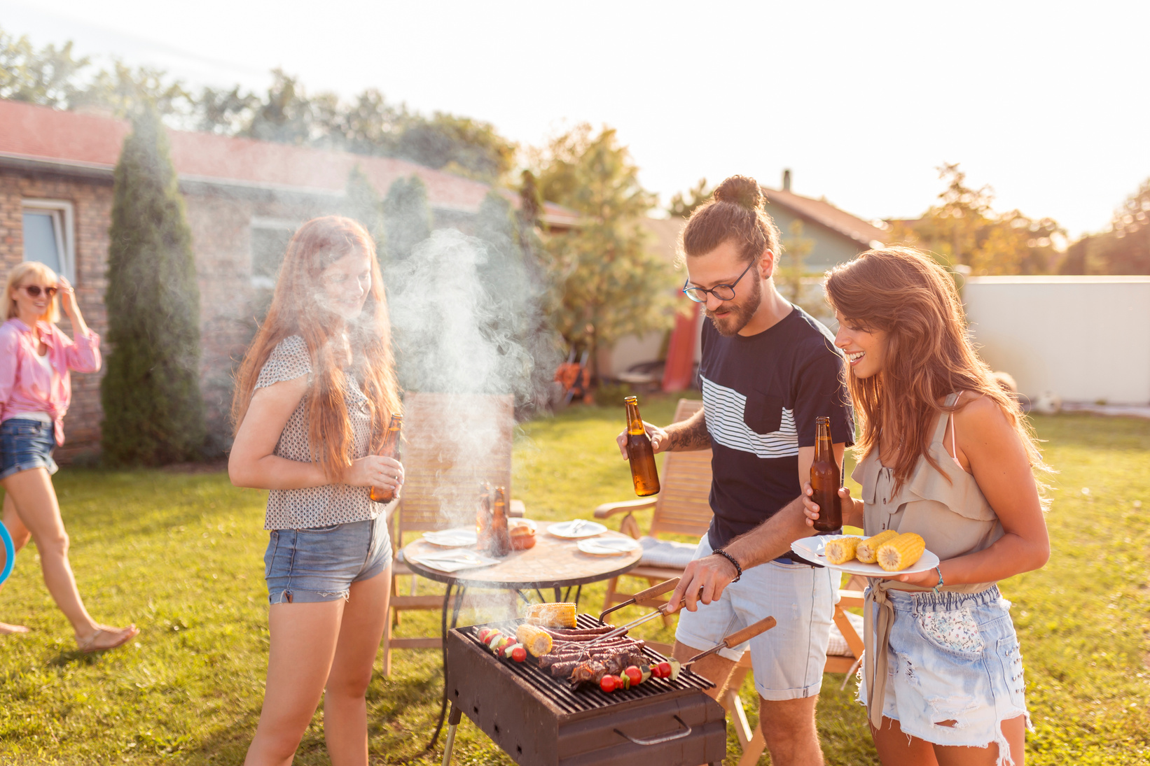 Young people having a backyard barbecue party